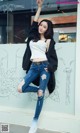 A woman in ripped jeans and a white top posing for a picture.