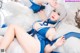 A woman in a blue and white outfit laying on a bed.