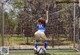 A woman in a blue and white uniform kicking a soccer ball.