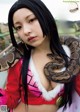 A woman holding a large snake in her hands.