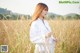 A woman standing in a field of tall grass.